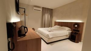 a hotel room with a bed and a television at sohho Hotel in Cukai