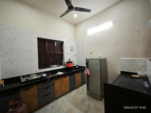 a kitchen with black counter tops and a refrigerator at Aeronest Villa "your new escape" in Udaipur