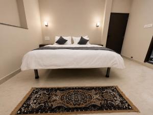 a bedroom with a large white bed with a rug at Aeronest Villa "your new escape" in Udaipur