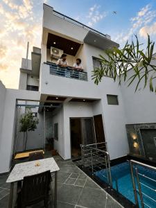 two people sitting on the balcony of a house at Aeronest Villa "your new escape" in Udaipur