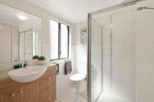 a bathroom with a toilet and a sink and a shower at Seachange Apartments Merimbula in Merimbula +83 photos