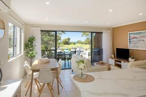 a living room with a couch and a table at Seachange Apartments Merimbula in Merimbula