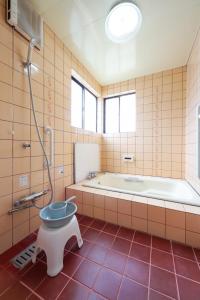a bathroom with a tub and a toilet in it at 湊の宿あまね in Hitachinaka +79 photos