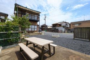 a picnic table and two benches on a street at 湊の宿あまね in Hitachinaka