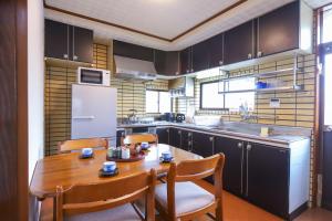 a small kitchen with a wooden table and chairs at 湊の宿あまね in Hitachinaka