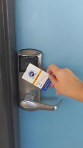 a person holding a credit card in front of a refrigerator at Ambassador Motor Lodge in Hervey Bay