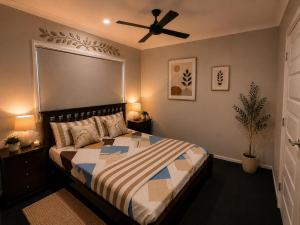 a bedroom with a bed and a ceiling fan at Guest House near theme parks in Pimpama