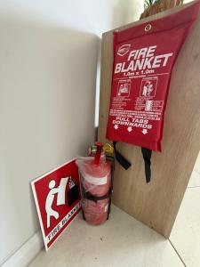 a fire hazard sign and a box next to a wall at Guest House near theme parks in Pimpama