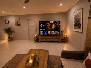 a living room with a couch and a tv at Guest House near theme parks in Pimpama