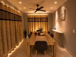 a dining room with a table and a ceiling fan at Guest House near theme parks in Pimpama