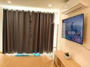 a living room with a tv and a large window at ลุงไซยเดอะแคมป์ in Ban Wang Hin Ngon