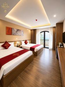a hotel room with two beds and a television at Lux Meris Hotel in Nhượng Bạn +7 photos