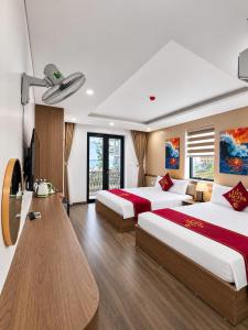 a hotel room with two beds and a table at Lux Meris Hotel in Nhượng Bạn