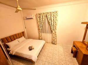 a bedroom with a bed with a pair of shoes on it at Wobbless Wonder Homestay in Bandar Seri Begawan
