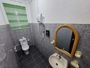 a bathroom with a sink and a toilet and a mirror at Wobbless Wonder Homestay in Bandar Seri Begawan +4 photos