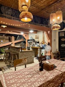 a dining room with a table and a bar at Alianna Homestay in Karimunjawa