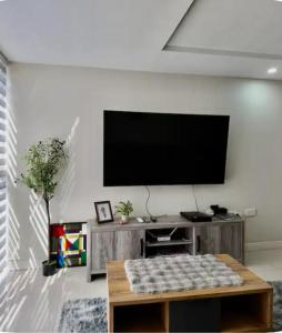 a living room with a flat screen tv on a wall at Royal Estate in Portmore