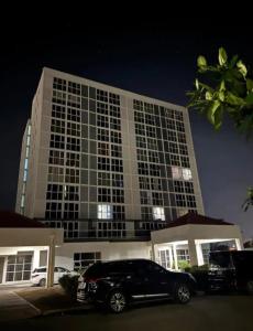 a black car parked in front of a large building at Royal Estate in Portmore