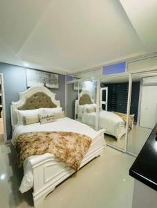 a bedroom with two beds and a large mirror at Royal Estate in Portmore