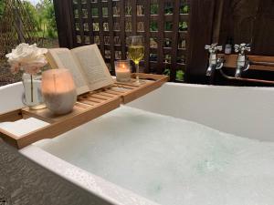 a bath tub with books and candles and a glass of wine at Quail Farm, Colonial charm in Nelson +46 photos