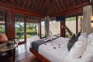 a bedroom with a bed with flowers on it at Temuku Ubud Villas in Ubud +83 photos