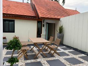 a wooden table and chairs on a patio at Villa Tara Khaolak in Khao Lak