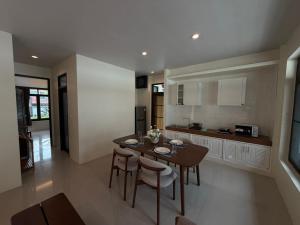 a kitchen and dining room with a table and chairs at Villa Tara Khaolak in Khao Lak