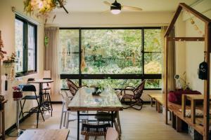 a room with a large window and tables and chairs at Tree House Café & Homestay in Tongluo