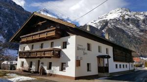 a building with wooden balconies and a mountain at Bauernhof Kuen in Längenfeld