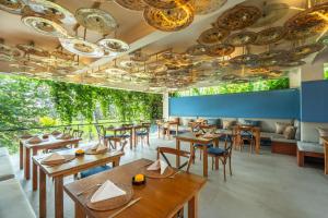 a restaurant with tables and chairs and chandeliers at Temuku Ubud Villas in Ubud