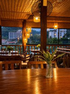 a restaurant with tables and chairs and a vase on a table at LIV Coron in Coron
