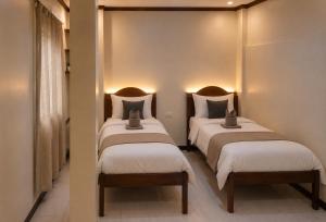 two twin beds in a room with lights at LIV Coron in Coron
