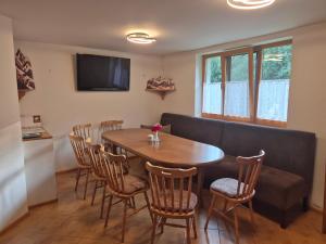 a dining room with a table and chairs and a couch at Nevesta hôľ pod Chopkom in Bystrá