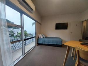 a room with a bed and a large window at Bayview Motel in Paihia