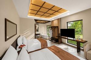 a living room with a bed and a television at Cuc Phuong Tropical Villas in Thượng Sung