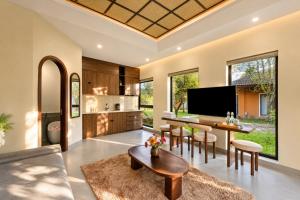 an open kitchen and living room with a table and chairs at Cuc Phuong Tropical Villas in Thượng Sung