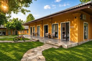 a house with a porch and a bike parked outside at Cuc Phuong Tropical Villas in Thượng Sung