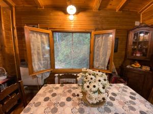 a table with a vase of flowers on top of it at Casa vacanza Chalet Baita nel Bosco in LʼAquila