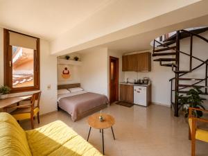a living room with a bed and a kitchen with a spiral staircase at Studio Acropolis Serres Parking EV Next to Center in Serres