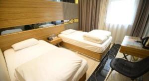 a hotel room with two beds and a desk at Hong Thai Hotel in Macau