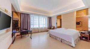 a hotel room with a bed and a television at Regency Hotel in Dongguan
