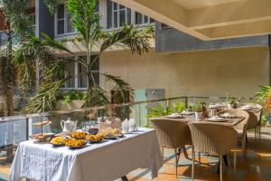 a table with food on it on a balcony at Hotel Carnival The Goa in Pilerne