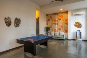 a ping pong table in the middle of a room at Hotel Carnival The Goa in Pilerne +131 photos