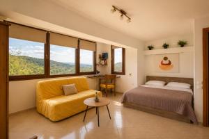 a bedroom with a bed and a chair and windows at Studio Acropolis Serres Parking EV Next to Center in Serres