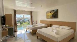 a hotel room with two beds and a window at Jeffrey S Hotel in Boracay