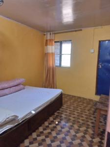 a small bedroom with a bed and a window at Doko Restaurant & Homestay in Heṭauḍā