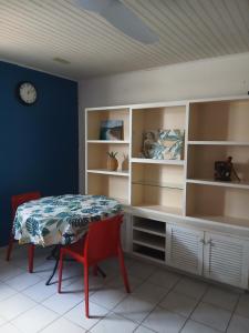 a dining room with a table and shelves at La vallée verte Martinique in Le Lamentin