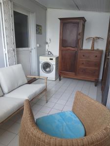 a living room with a couch and a washing machine at La vallée verte Martinique in Le Lamentin