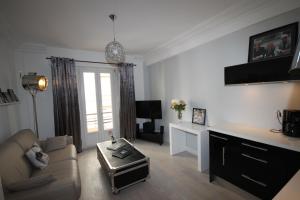 a living room with a couch and a table at From Hollywood to Bollywood 2 Bedrooms 2 Bathrooms - 1 min from Croisette&Beach, 12 Min from the Palais in Cannes