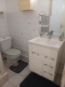 a bathroom with a white sink and a toilet at La vallée verte Martinique in Le Lamentin